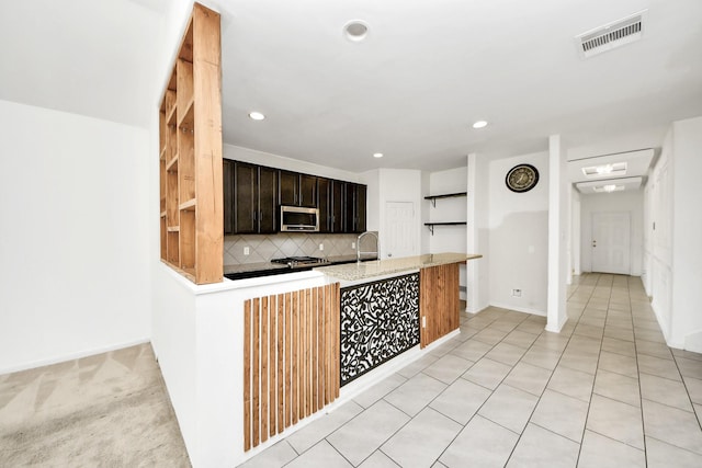 3619 Barkers Run Dr, Houston, TX 77084 - kitchen with stainless steel microwave, decorative backsplash, recessed lighting, and light stone counters
