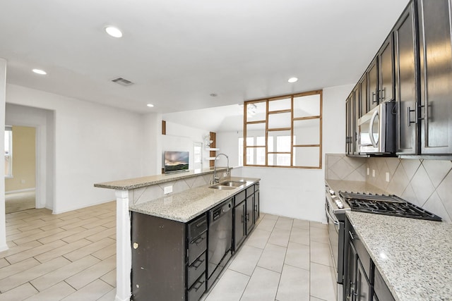 3619 Barkers Run Dr, Houston, TX 77084 - kitchen featuring stainless steel appliances, tasteful backsplash, recessed lighting, light stone countertops, and open floor plan