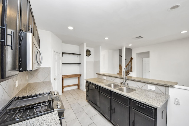 3619 Barkers Run Dr, Houston, TX 77084 - kitchen with stainless steel appliances, decorative backsplash, recessed lighting, light stone countertops, and light tile patterned flooring