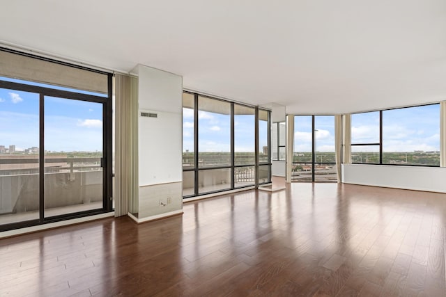 15 Greenway Plz Unit 10G, Houston, TX 77046 - spare room featuring a wall of windows, wood finished floors, and healthy amount of natural light