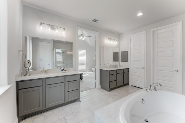 6907 Pondhawk Dr, Katy, TX 77493 - full bathroom with two vanities, a ceiling fan, a bath, a shower stall, and tile patterned floors
