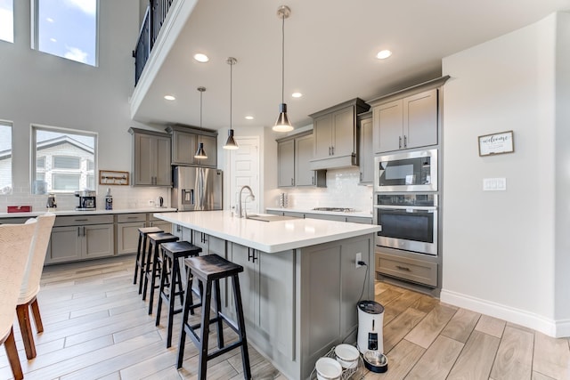 6907 Pondhawk Dr, Katy, TX 77493 - kitchen featuring appliances with stainless steel finishes, gray cabinetry, light countertops, decorative backsplash, and recessed lighting