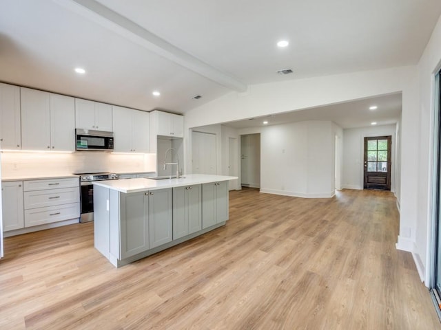 527 Blakeley Dr, San Antonio, TX 78209 - kitchen with stainless steel appliances, backsplash, light wood-type flooring, light countertops, and a kitchen island with sink