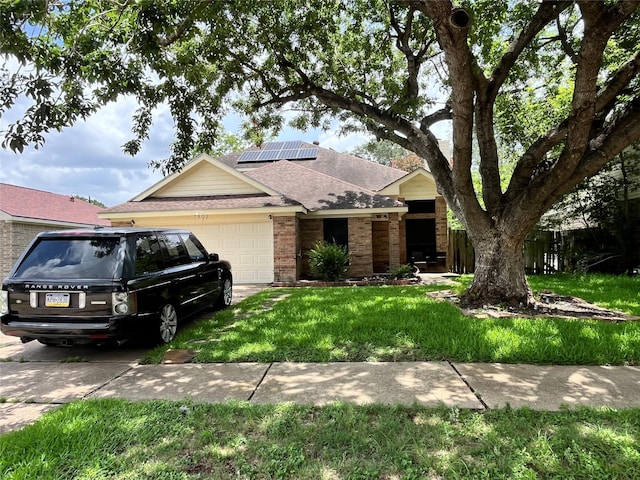 7502 Grackle Dr, Cypress, TX 77433 - single story home featuring brick siding, a garage, roof mounted solar panels, a front yard, and a shingled roof