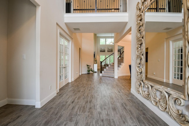 9411 Plaza Point Dr, Missouri City, TX 77459 - foyer featuring a towering ceiling, wood finished floors, and stairway