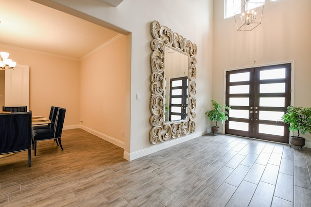 9411 Plaza Point Dr, Missouri City, TX 77459 - entrance foyer featuring a chandelier, crown molding, french doors, wood finished floors, and a high ceiling