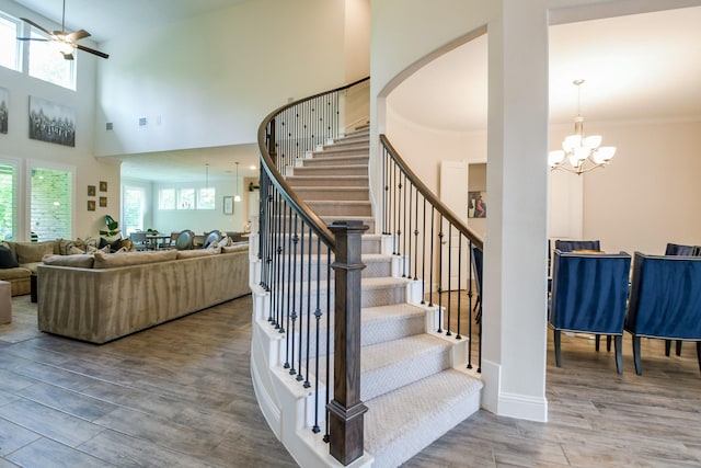 9411 Plaza Point Dr, Missouri City, TX 77459 - staircase with a ceiling fan, a chandelier, wood finished floors, ornamental molding, and a high ceiling