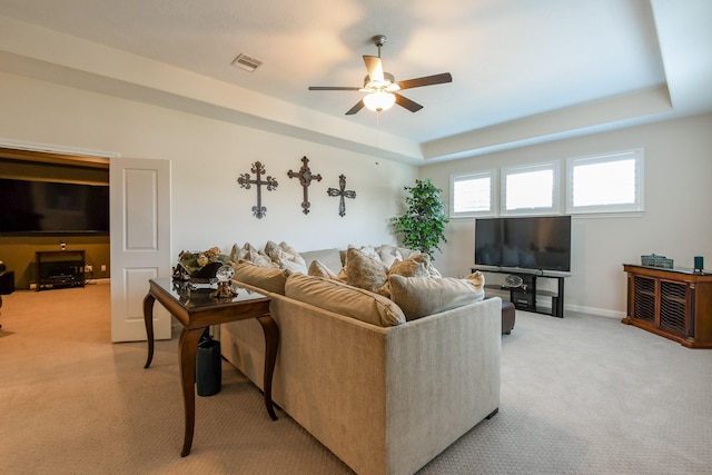 9411 Plaza Point Dr, Missouri City, TX 77459 - living room featuring light carpet, a ceiling fan, and a raised ceiling
