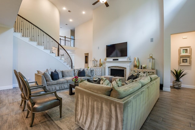 9411 Plaza Point Dr, Missouri City, TX 77459 - living room with a towering ceiling, wood finished floors, stairway, a ceiling fan, and a fireplace