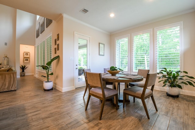9411 Plaza Point Dr, Missouri City, TX 77459 - dining space with wood finished floors, crown molding, and recessed lighting