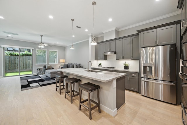 408 W Pierce St, Houston, TX 77019 - kitchen with appliances with stainless steel finishes, open floor plan, light wood-style floors, light stone countertops, and a breakfast bar area