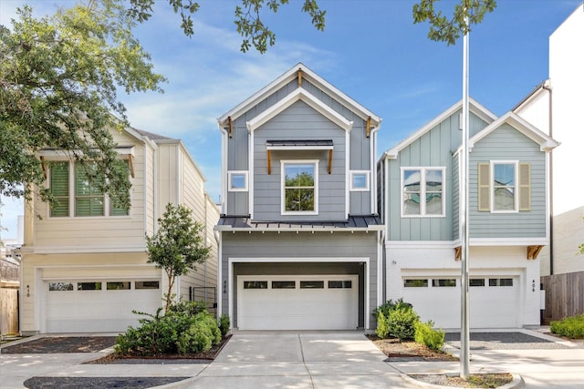 408 W Pierce St, Houston, TX 77019 - view of front of house featuring board and batten siding, a garage, driveway, and a metal roof