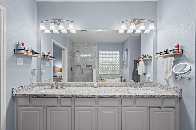 1011 Elm Pointe, League City, TX 77573 - full bathroom featuring a tile shower, a textured wall, and double vanity