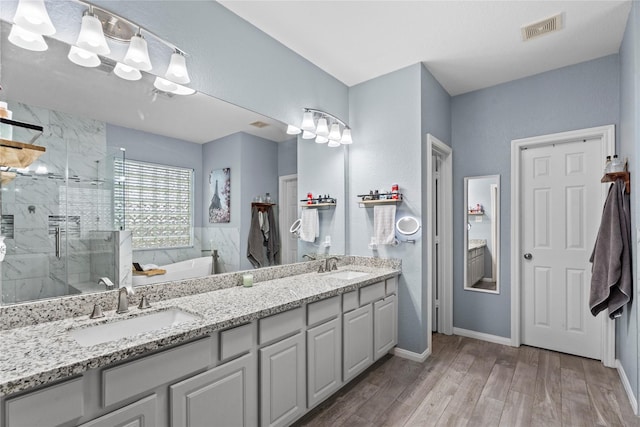 1011 Elm Pointe, League City, TX 77573 - full bathroom featuring a garden tub, double vanity, a marble finish shower, and wood finished floors