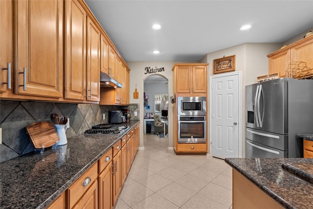 1011 Elm Pointe, League City, TX 77573 - kitchen with appliances with stainless steel finishes, under cabinet range hood, tasteful backsplash, arched walkways, and recessed lighting