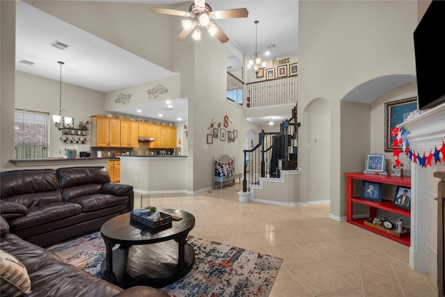 1011 Elm Pointe, League City, TX 77573 - living area with a chandelier, light tile patterned floors, a ceiling fan, arched walkways, and a high ceiling
