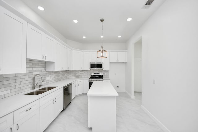 8159 Crestview Dr, Houston, TX 77028 - kitchen featuring appliances with stainless steel finishes, decorative backsplash, a center island, white cabinetry, and recessed lighting