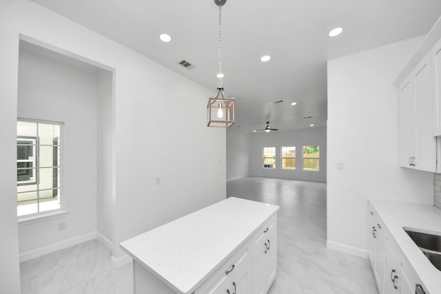 8159 Crestview Dr, Houston, TX 77028 - kitchen featuring recessed lighting, light countertops, hanging light fixtures, white cabinets, and a kitchen island