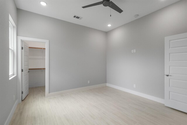 301 Knights Row, Horseshoe Bay, TX 78657 - unfurnished bedroom with a walk in closet, light wood-style floors, recessed lighting, a closet, and ceiling fan