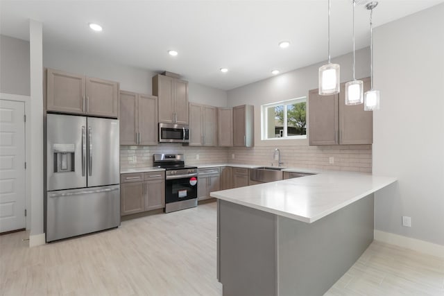 301 Knights Row, Horseshoe Bay, TX 78657 - kitchen featuring appliances with stainless steel finishes, a peninsula, tasteful backsplash, light countertops, and recessed lighting