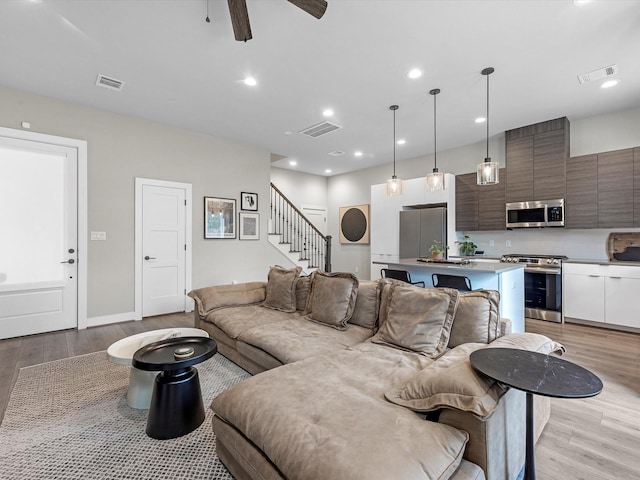 307 Charlock St, Houston, TX 77022 - living area featuring light wood-type flooring, stairs, ceiling fan, and recessed lighting