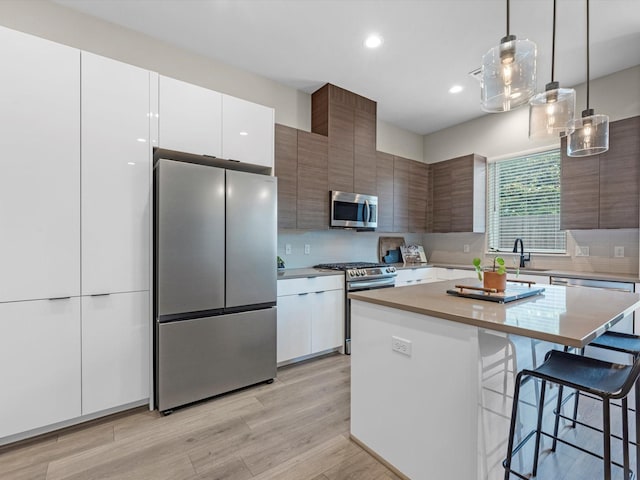 307 Charlock St, Houston, TX 77022 - kitchen featuring appliances with stainless steel finishes, modern cabinets, a breakfast bar, light countertops, and recessed lighting