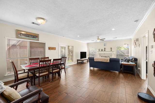 7202 N Fawn River Cir, Spring, TX 77379 - living room with a textured ceiling, a ceiling fan, ornamental molding, a tile fireplace, and dark wood-type flooring