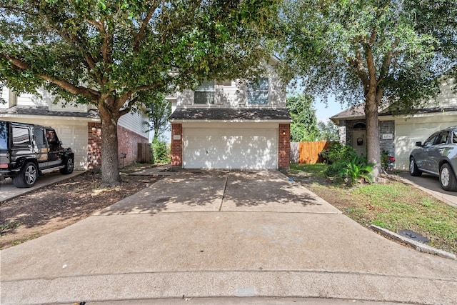 6810 Strathmore Place Ct, Katy, TX 77449 - view of property hidden behind natural elements featuring brick siding, concrete driveway, and an attached garage