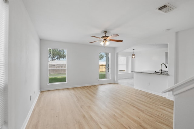 6810 Strathmore Place Ct, Katy, TX 77449 - unfurnished living room featuring plenty of natural light, light wood finished floors, and a ceiling fan