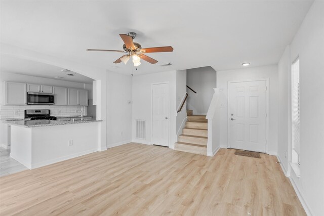 6810 Strathmore Place Ct, Katy, TX 77449 - unfurnished living room featuring ceiling fan, light wood-style flooring, stairway, and recessed lighting