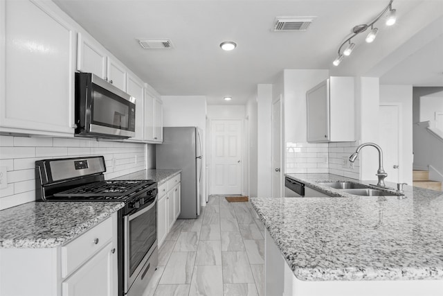 6810 Strathmore Place Ct, Katy, TX 77449 - kitchen featuring stainless steel appliances, light stone countertops, light marble finish floors, white cabinetry, and recessed lighting