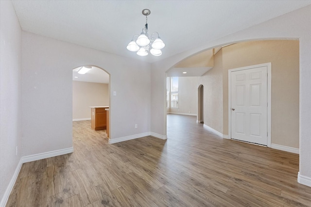16546 Whitaker Creek Dr, Houston, TX 77095 - unfurnished room featuring arched walkways, wood finished floors, and a chandelier