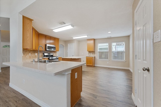 16546 Whitaker Creek Dr, Houston, TX 77095 - kitchen featuring appliances with stainless steel finishes, tasteful backsplash, light countertops, and light wood-type flooring