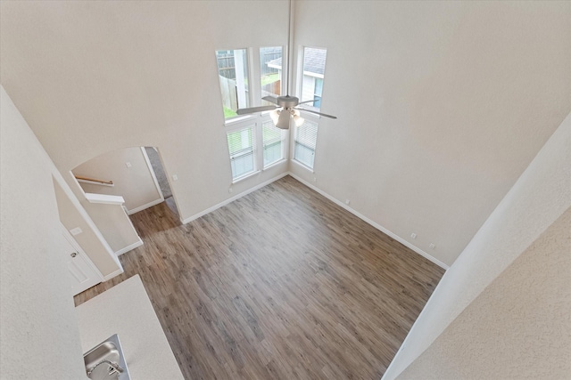 16546 Whitaker Creek Dr, Houston, TX 77095 - unfurnished living room featuring a ceiling fan, arched walkways, and wood finished floors