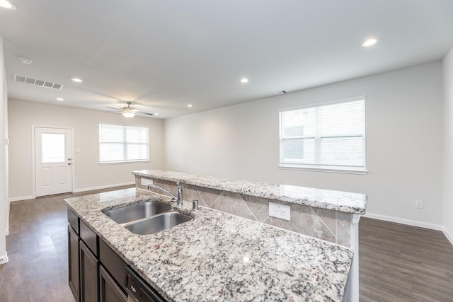 2931 Orchid Ranch Dr, Katy, TX 77494 - kitchen with an island with sink, ceiling fan, dark wood finished floors, light stone counters, and recessed lighting