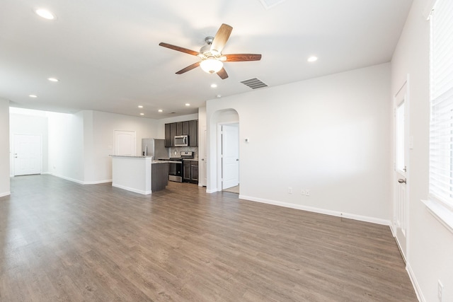 2931 Orchid Ranch Dr, Katy, TX 77494 - unfurnished living room with a ceiling fan, recessed lighting, dark wood finished floors, and arched walkways
