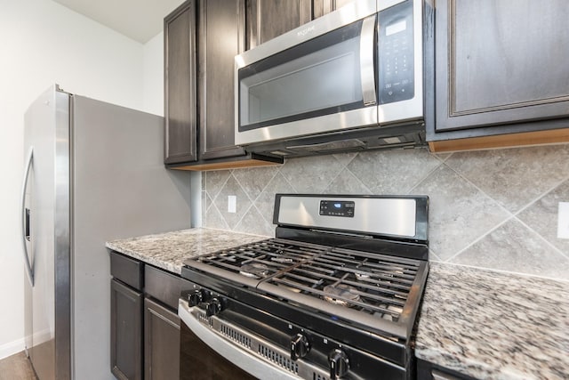 2931 Orchid Ranch Dr, Katy, TX 77494 - kitchen with appliances with stainless steel finishes, light stone countertops, dark brown cabinets, and backsplash