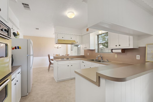 3009 Stacy Ln, Deer Park, TX 77536 - kitchen with a peninsula, white appliances, white cabinets, and light countertops