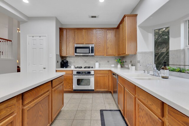 2331 Fern Bend Ln, Katy, TX 77494 - kitchen featuring appliances with stainless steel finishes, tasteful backsplash, light countertops, light tile patterned flooring, and recessed lighting