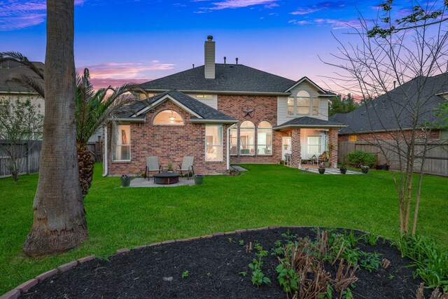 2331 Fern Bend Ln, Katy, TX 77494 - back of house at dusk featuring a patio, a chimney, brick siding, and a fenced backyard