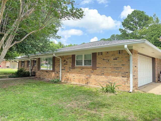 1502 Robin St, Mineola, TX 75773 - ranch-style house featuring an attached garage, a front lawn, brick siding, and driveway