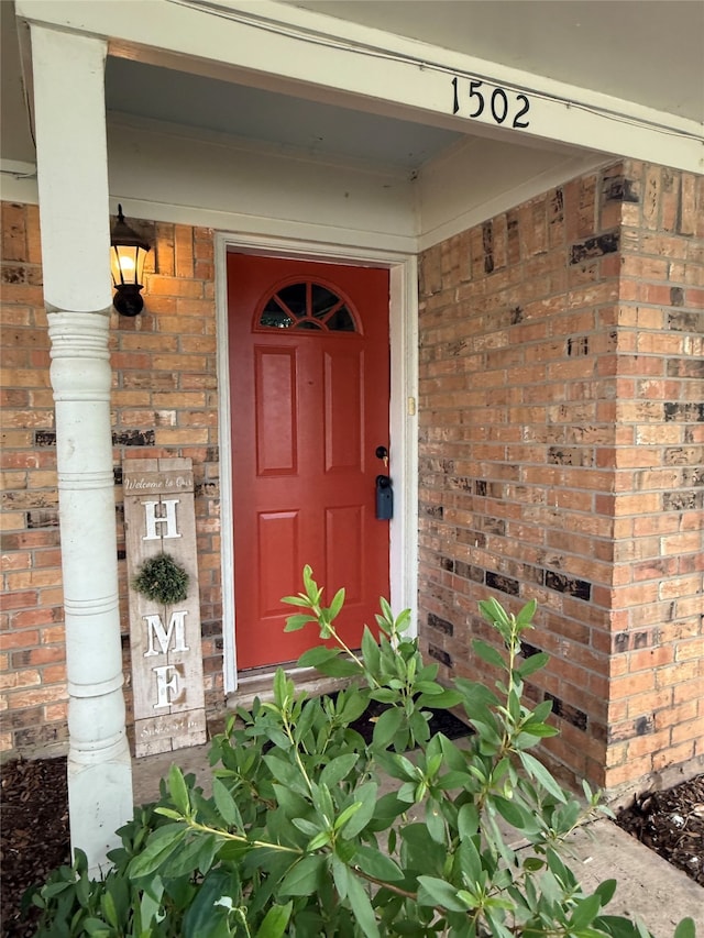 1502 Robin St, Mineola, TX 75773 - doorway to property featuring brick siding and covered porch