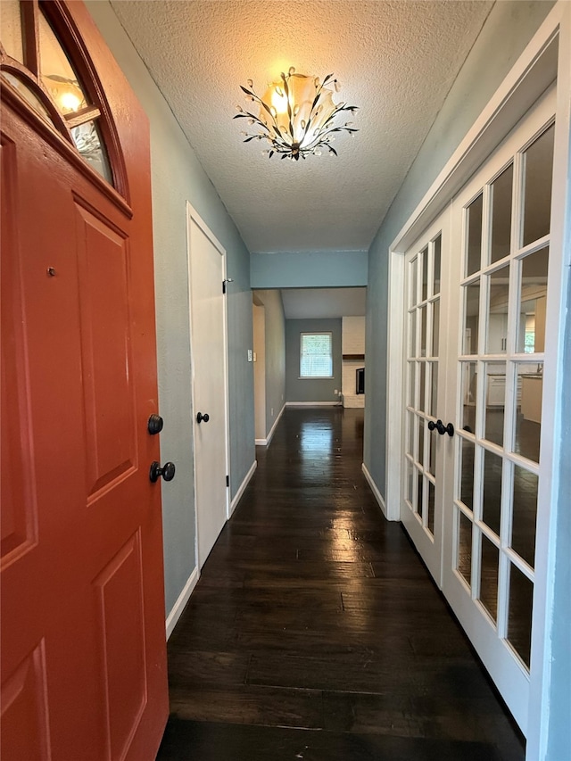 1502 Robin St, Mineola, TX 75773 - corridor featuring french doors, a textured ceiling, and dark wood-style floors
