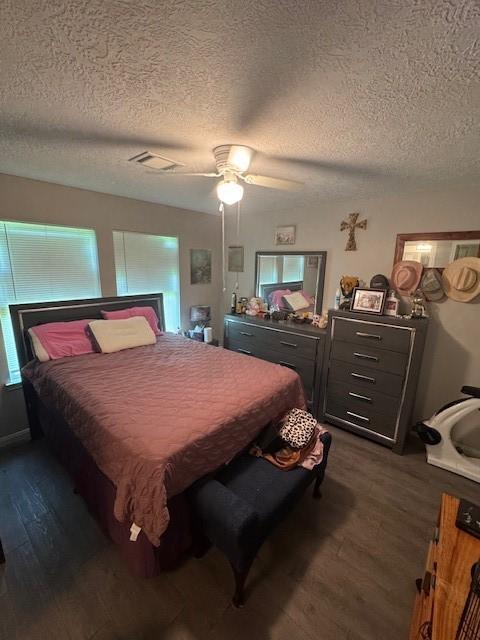 3940 Frontier Rd, Willis, TX 77378 - bedroom featuring dark wood-style flooring, a textured ceiling, and ceiling fan