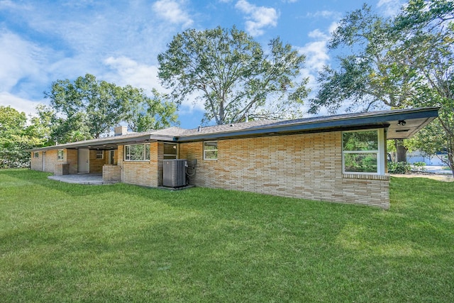 1805 E Ave, Katy, TX 77493 - back of house featuring a lawn, brick siding, a chimney, and a patio