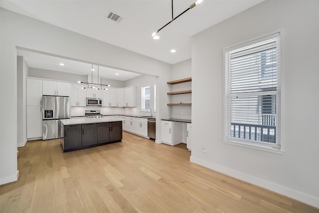 2206 Lou Ellen Ln Unit C, Houston, TX 77018 - kitchen with appliances with stainless steel finishes, white cabinetry, light wood-type flooring, a center island, and recessed lighting