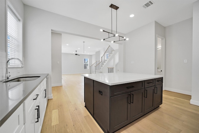 2206 Lou Ellen Ln Unit C, Houston, TX 77018 - kitchen with light wood-type flooring, a ceiling fan, white cabinets, dark brown cabinets, and recessed lighting