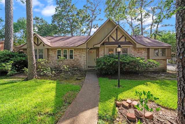 23011 Elephant Walk St, Spring, TX 77389 - tudor-style house with brick siding, a front yard, board and batten siding, and roof with shingles