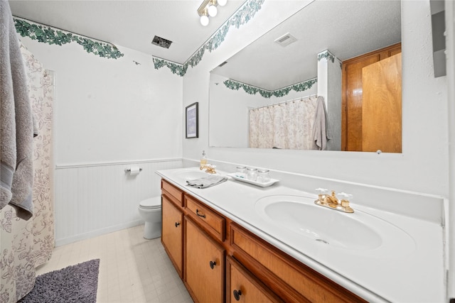 23011 Elephant Walk St, Spring, TX 77389 - bathroom with double vanity, a wainscoted wall, tile patterned floors, and a shower with shower curtain