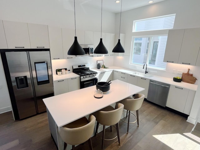 303F Marcella St, Houston, TX 77091 - kitchen with stainless steel appliances, backsplash, wood finished floors, modern cabinets, and recessed lighting